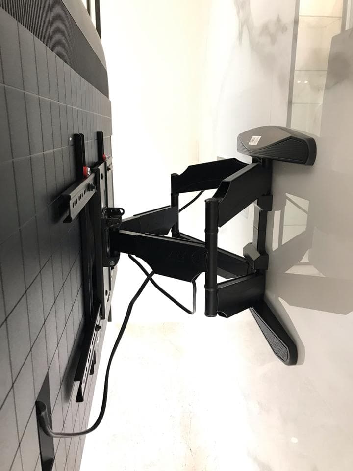 這張照片是一個電視牆壁支架,它是由黑色金屬製成,可以旋轉和傾斜,讓電視可以更容易地觀看。