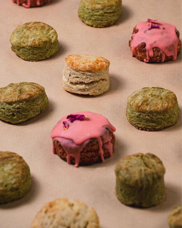 這張「各式各樣的小點心」的照片是,有綠色的、粉紅色的、以及原色的點心,上面有裝飾,很吸引人。