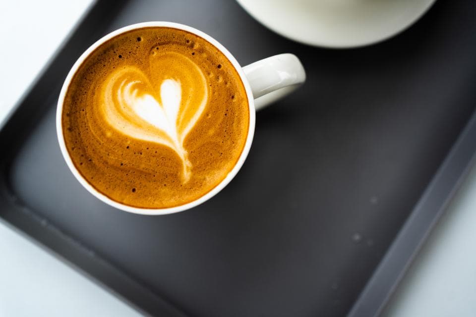 這張照片是一杯裝飾著愛心拉花的咖啡,它看起來香濃誘人。