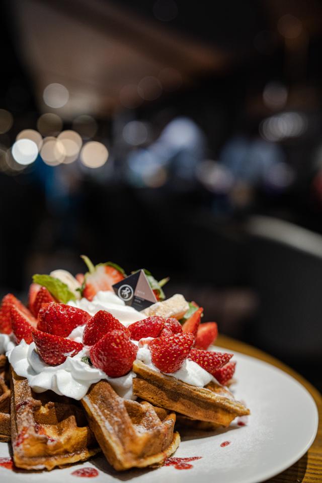 這張「鬆餅」的照片是一份淋上鮮奶油和草莓的鬆餅,看起來非常美味。