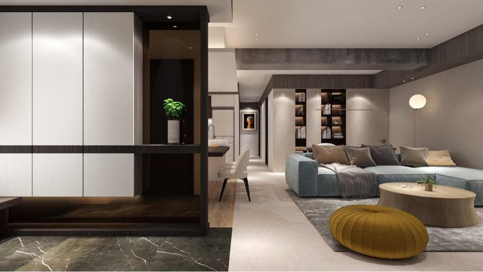 這張照片是一個現代化的客廳,最顯眼的是中間的沙發和茶几。沙發呈L型,以淺藍色為主色調,搭配舒適的抱枕,茶几則是圓形,上面擺放著綠色盆栽,展現出簡約時尚的風格。