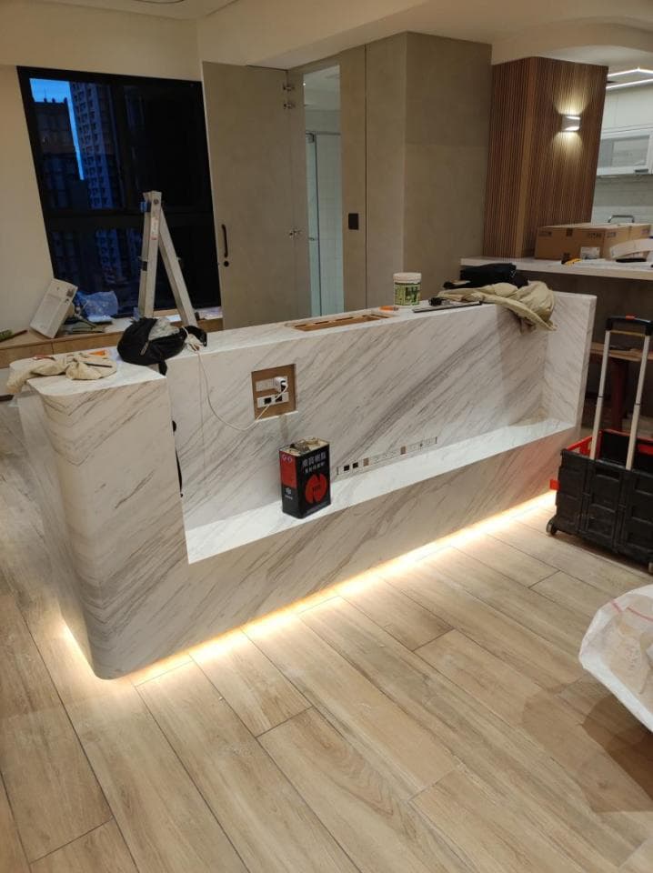 這張照片是一張裝修中的臥室照片,最顯眼的是房間裡鋪設的木地板,以及牆上安裝的隱藏式燈帶。