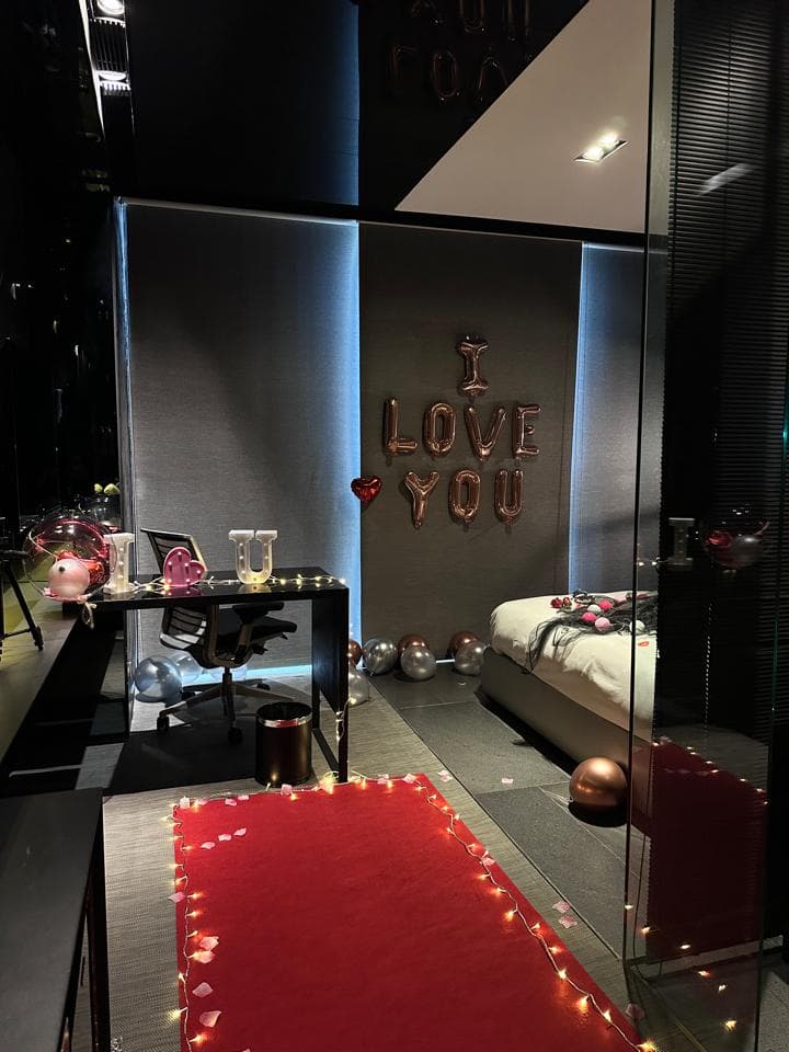 這張照片是一間房間,房間裡有一張紅色地毯,地毯上有著閃閃發光的燈光,佈置得非常浪漫。