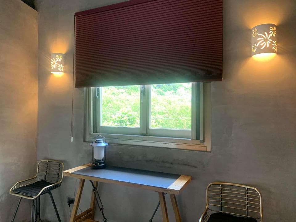 1) 照片顯示一個房間,房間內有一個窗戶、一張桌子、兩張椅子和一個燈