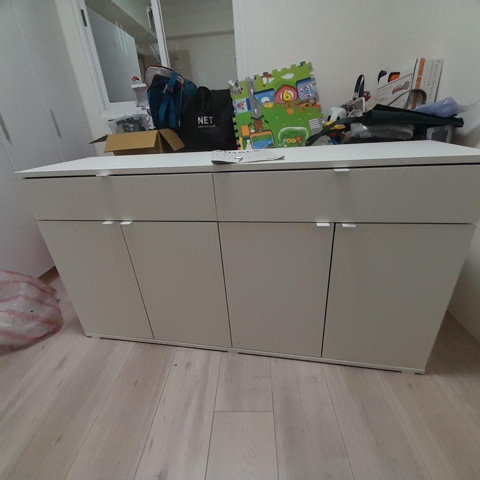 這張照片是一張白色櫥櫃,上面有四個門和兩個抽屜。櫥櫃的材質看起來很光滑,門把手是金屬材質。櫥櫃整體設計簡潔,非常適合現代家居風格。