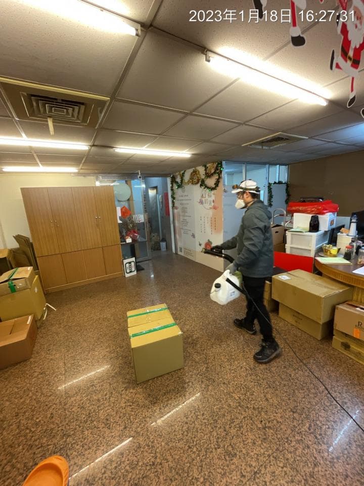 1) 照片顯示一名戴著口罩的男子正在用消毒噴霧器清潔辦公室