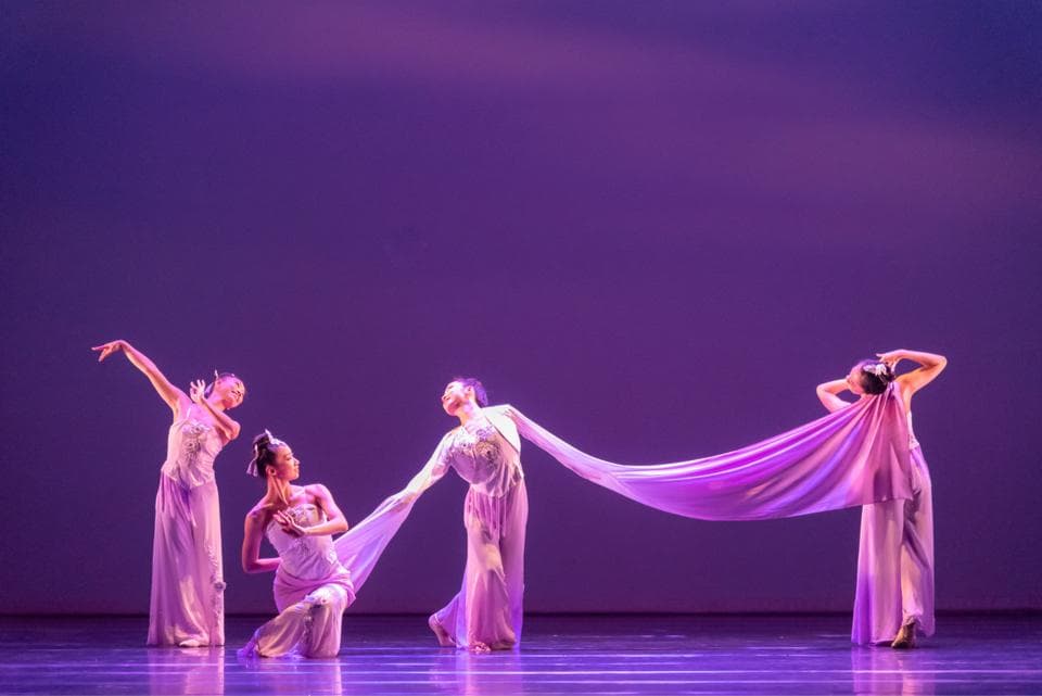 1) 照片展示了四位穿著淡紫色服裝的舞者在舞台上表演