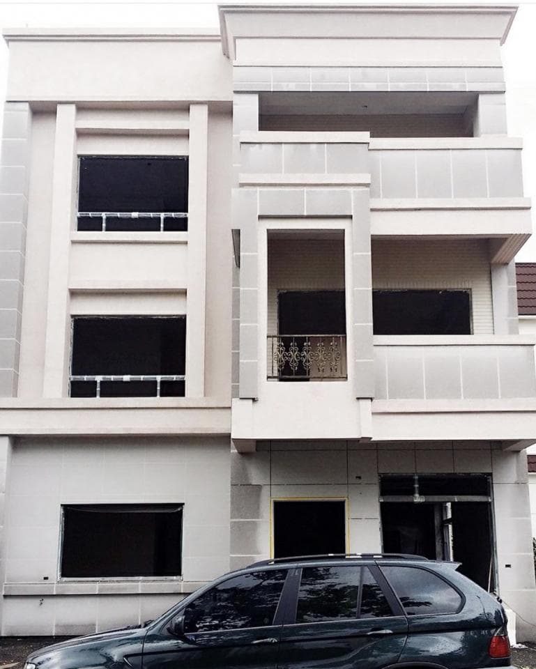 這張照片是一輛黑色休旅車停在現代化建築物前。