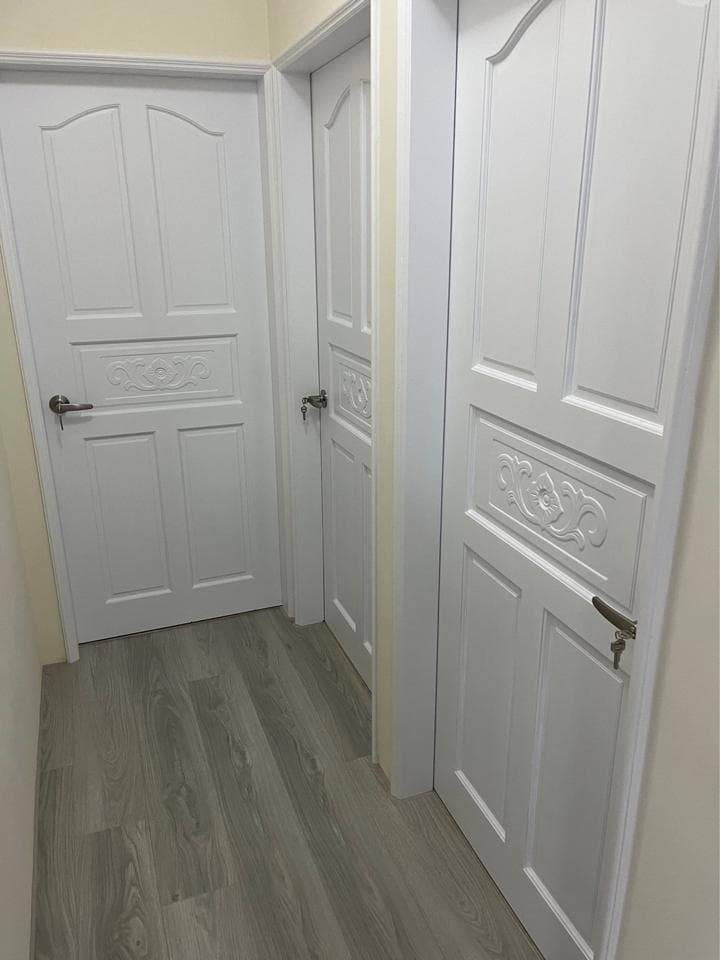 1) 照片顯示一個走廊,走廊上有三扇白門