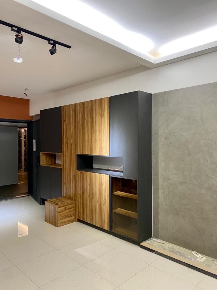 這張照片是一個現代化的客廳,主要特色是牆壁上的木質和黑色收納櫃,搭配淺色地板,整體簡約而時尚。