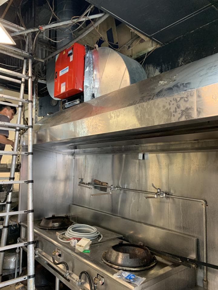 這張「廚房」的照片是一家餐廳的廚房,照片中可以看見一個大型的排油煙機和兩個大鍋。