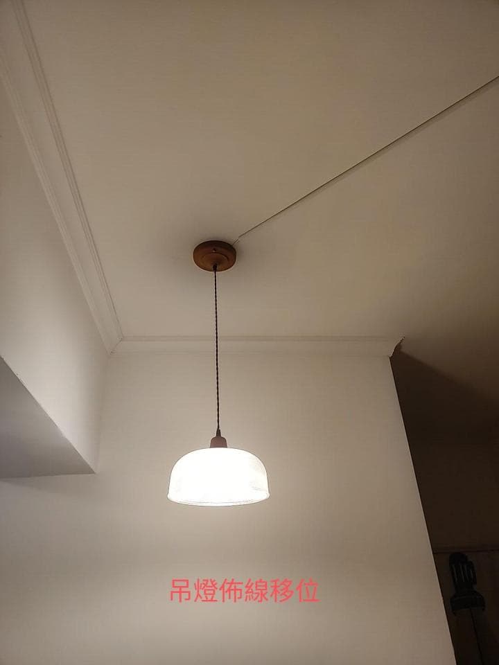 1) 照片顯示一個單獨的白色燈罩吊燈,從天花板懸掛下來,安裝在一個白色天花板的角落,燈罩是乳白色,燈光很柔和