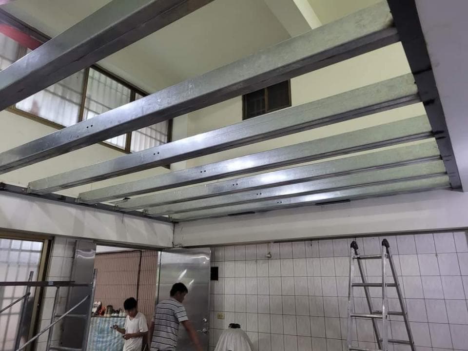 這張「室內裝修」的照片是顯示一個房間的屋頂正在進行施工,照片裡可以看到幾位工人正在安裝鋼樑,看起來像是正在進行房屋的加建工程。