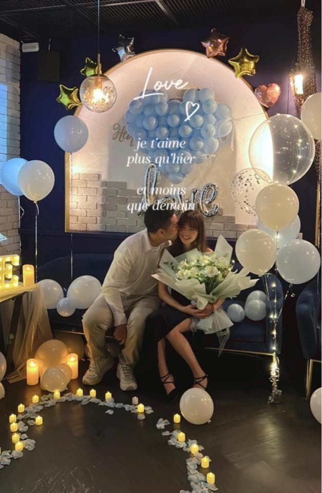 這張照片是情侶在浪漫的佈置下,男方正在向女方求婚。