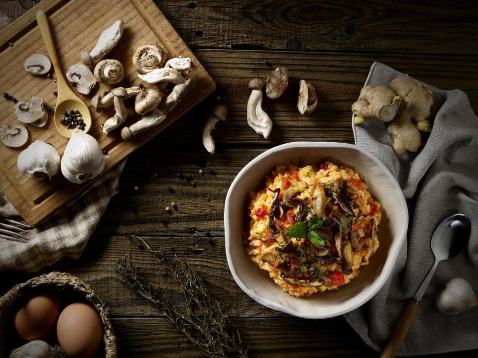 這張「蘑菇燉飯」的照片是一盤用新鮮香菇、番茄醬和香草製成的燉飯,配上香菇、薑和雞蛋。