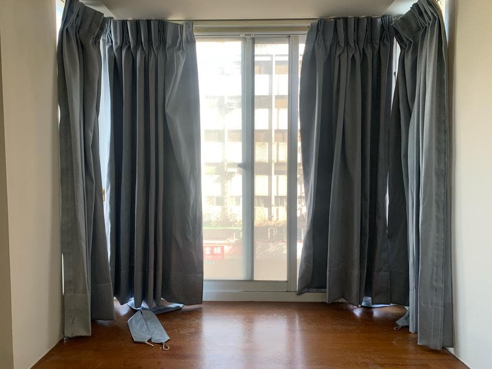 這張照片是一間房間的窗戶,窗戶上有四層灰色的窗簾。