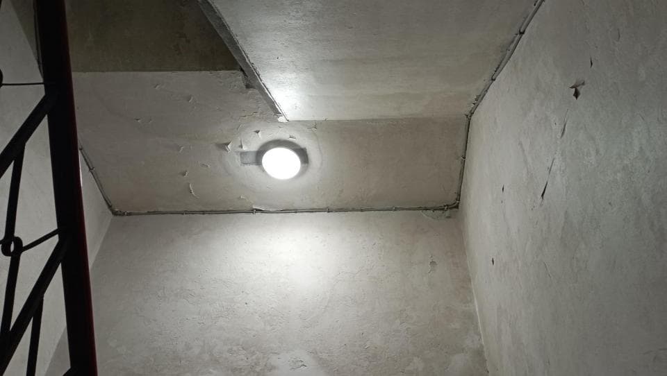 1) 照片顯示一個白色牆壁的角落,有一個燈光照亮了這個角落