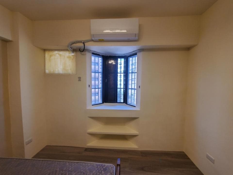 1) 照片顯示一個簡潔的房間,房間內部有白色牆壁和淺色木地板