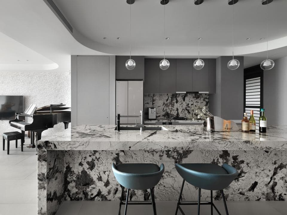 這張照片是現代化的廚房,最重要的是那張巨大的石英石檯面。檯面上有灰白色大理石紋路,看起來非常高級。
