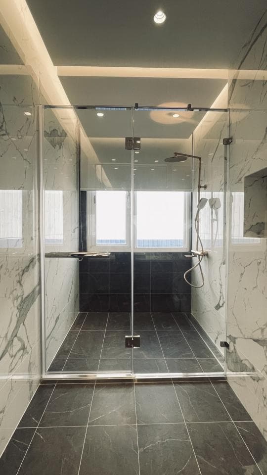 1. 照片顯示一個帶有黑色地磚的現代淋浴間,裝有玻璃門和牆壁
