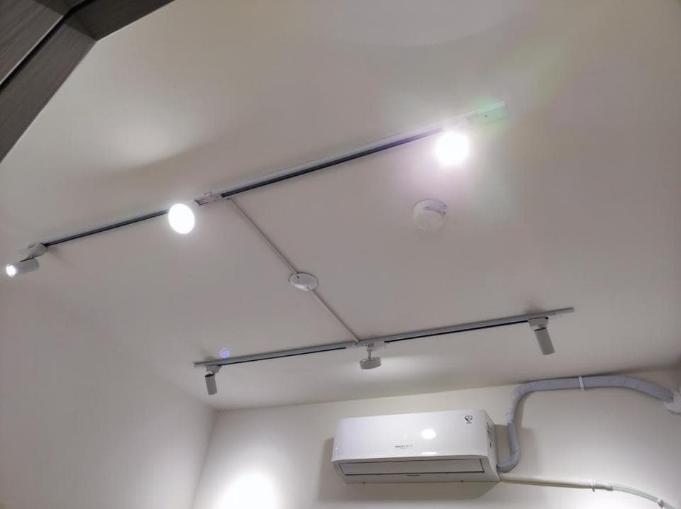 1) 照片顯示一個白色天花板,天花板上裝有軌道燈,並有部分電線外露