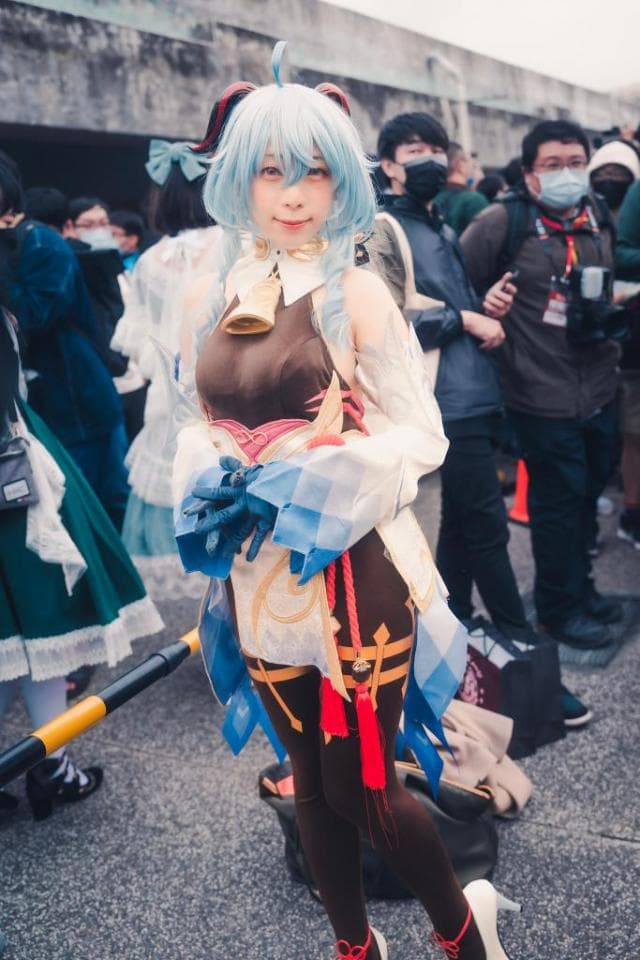 這張「Cosplay」的照片是一個穿著白色和藍色衣服的女孩,她有著藍色的頭髮和紅色的眼睛,她正在擺出一個可愛的姿勢。