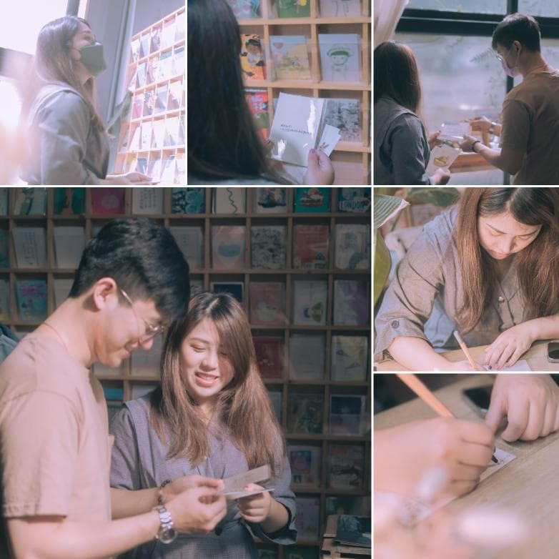 這張「多人互動」的照片是,一個年輕男女在書架前選擇明信片,一位女生在桌子前寫明信片,還有一位男生站在窗邊看風景。