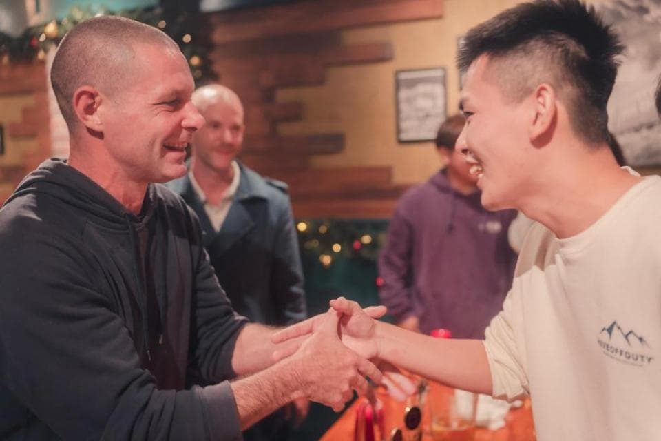 這張「兩個男人握手」的照片是在一個酒吧裡,他們看起來很開心的樣子。