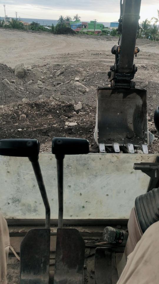 1) 照片顯示一台挖掘機的駕駛室,駕駛座左側有兩根控制桿,駕駛座右側有操作桿,駕駛座前方可看到挖掘機的鏟斗