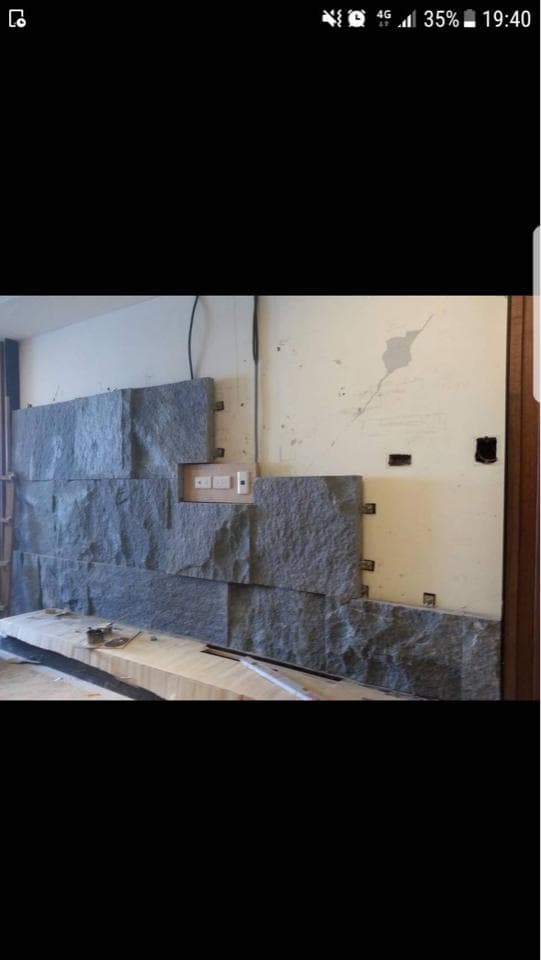 這張照片是一面用石頭砌成的牆,石頭排列整齊,呈現出粗獷自然的質感。