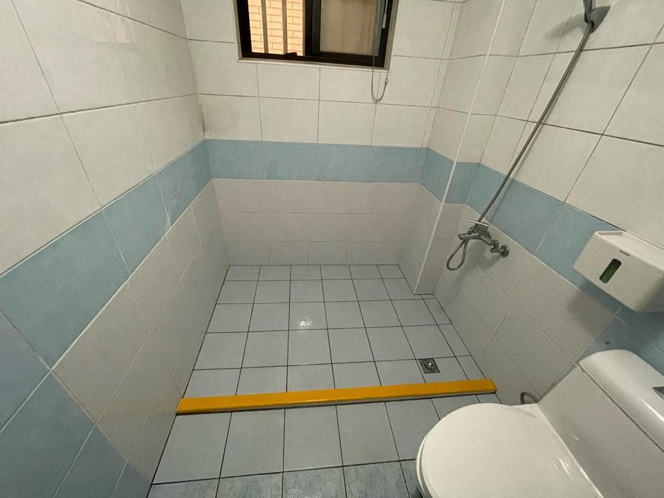 1) 照片顯示一個浴室,裡面有淋浴間、馬桶、瓷磚地板和牆壁