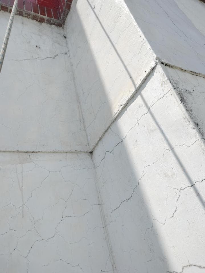 1) 這張照片顯示了一棟建築物的牆壁,牆壁上有裂縫,牆壁是白色的