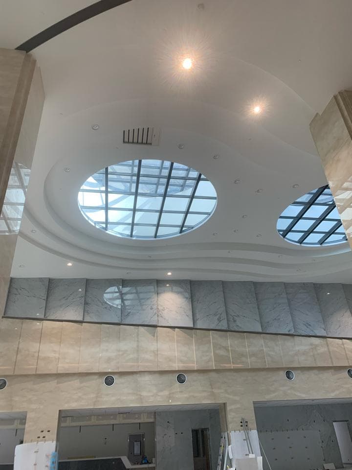 1) 這張照片顯示一個大型建築物的內部,帶有彎曲的白色天花板和兩個天窗