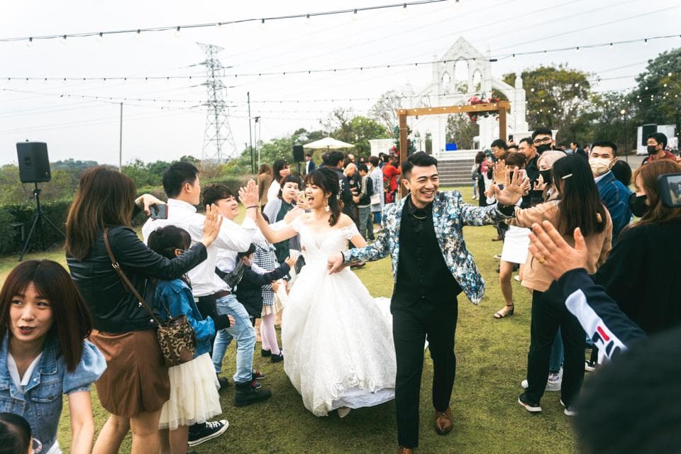 這張照片是婚禮現場,最重要的是一對新人正在互相擁抱,新娘穿著優雅的婚紗,新郎則穿著帥氣的西裝,他們正在分享他們的喜悅和幸福。