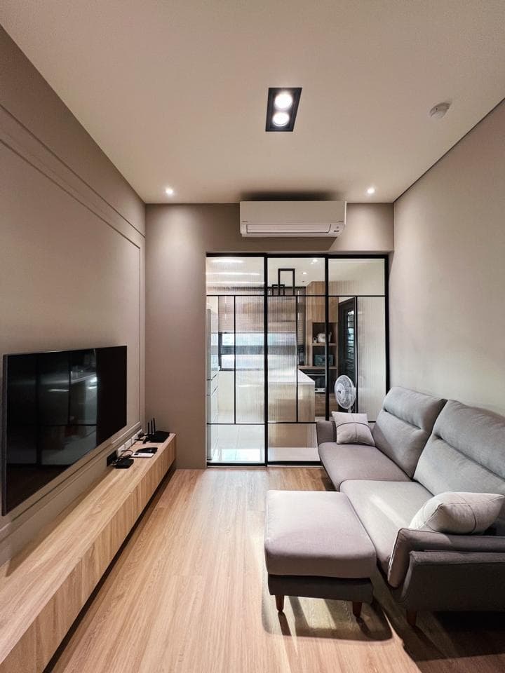 1) 這是一張現代風格客廳的照片,照片中有一個大型的電視、一個木質電視櫃、一個灰色沙發、一張沙發椅和一個玻璃門