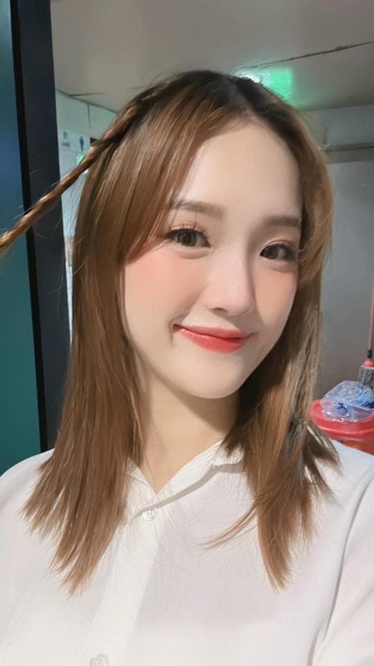 這張「女生自拍」的照片是一個年輕女生穿著白色襯衫,笑容甜美,頭髮編成辮子,看起來很可愛。
