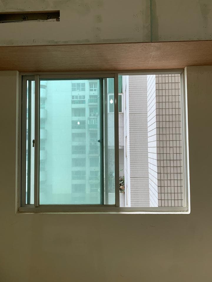 1) 照片顯示一個房間裡的一扇窗戶,窗戶外是另一棟建築物