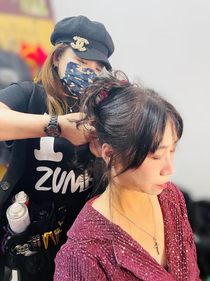 這張照片是兩個女人在做頭髮,其中一個正在幫另一個女人整理頭髮。她們看起來很友善,而且很享受彼此的陪伴。