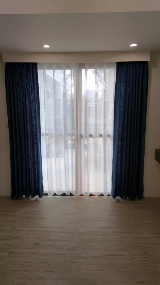 1) 照片顯示一個房間的窗戶,窗戶上有藍色的窗簾和白色的窗紗