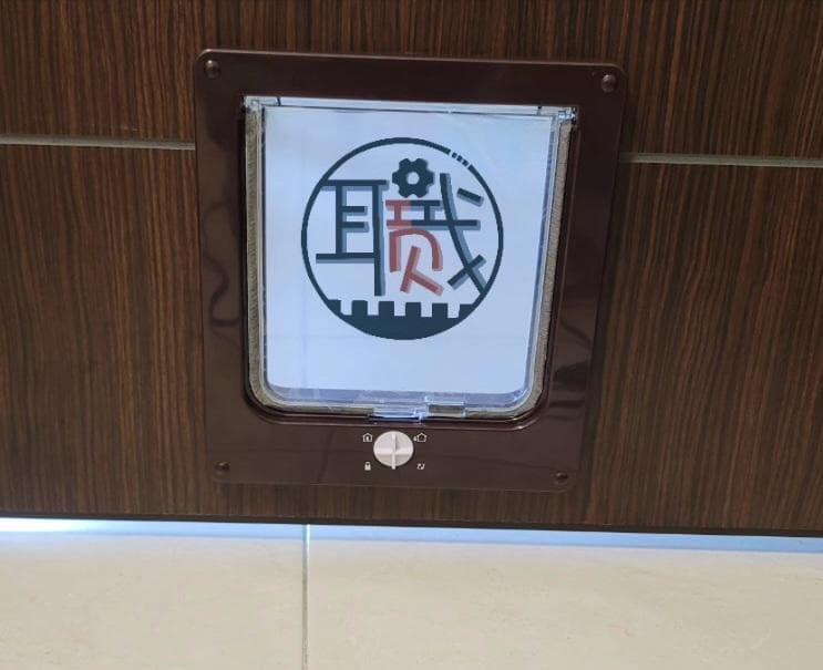 1) 照片顯示的是一個棕色木門上的貓門,貓門上有一個白色標誌,上面寫著「正反」
