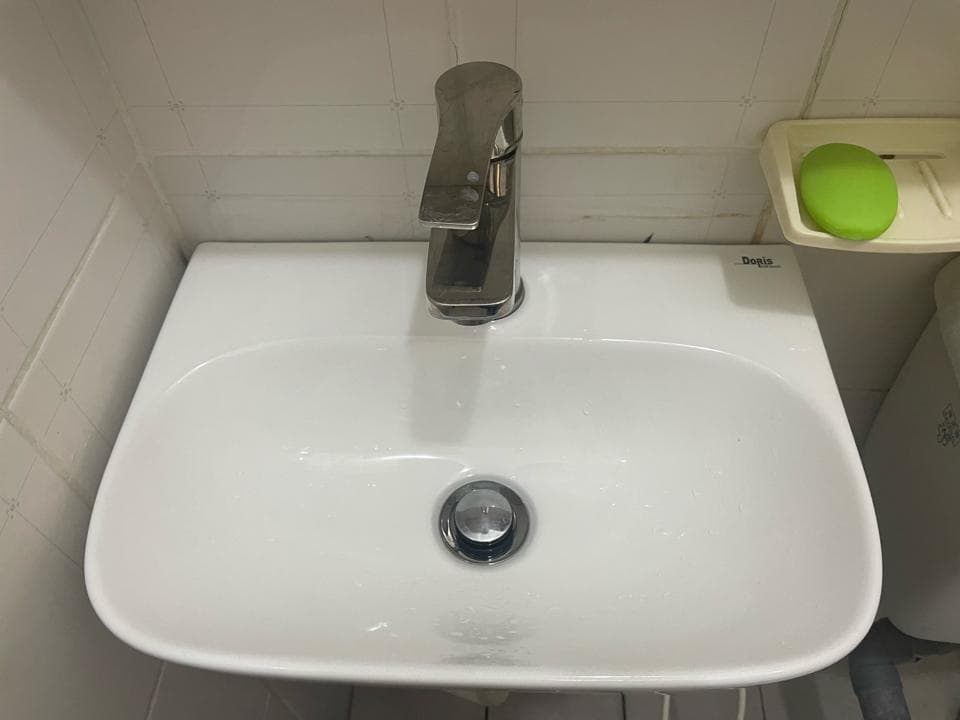 1) 照片顯示一個白色陶瓷洗手台,上面有一個銀色的水龍頭