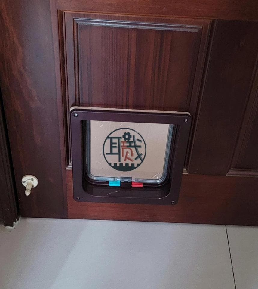 1) 照片顯示一個木製門,門上安裝了一個寵物門,寵物門上有一個標籤,上面寫著「日安」