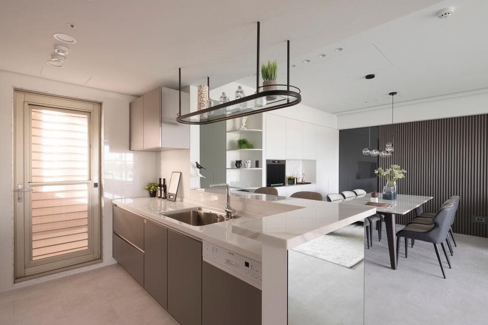 這張照片是一間現代化廚房,最重要的是中間的白色大理石吧檯,它將廚房空間與餐廳空間分隔開來,同時也提供了額外的料理空間。