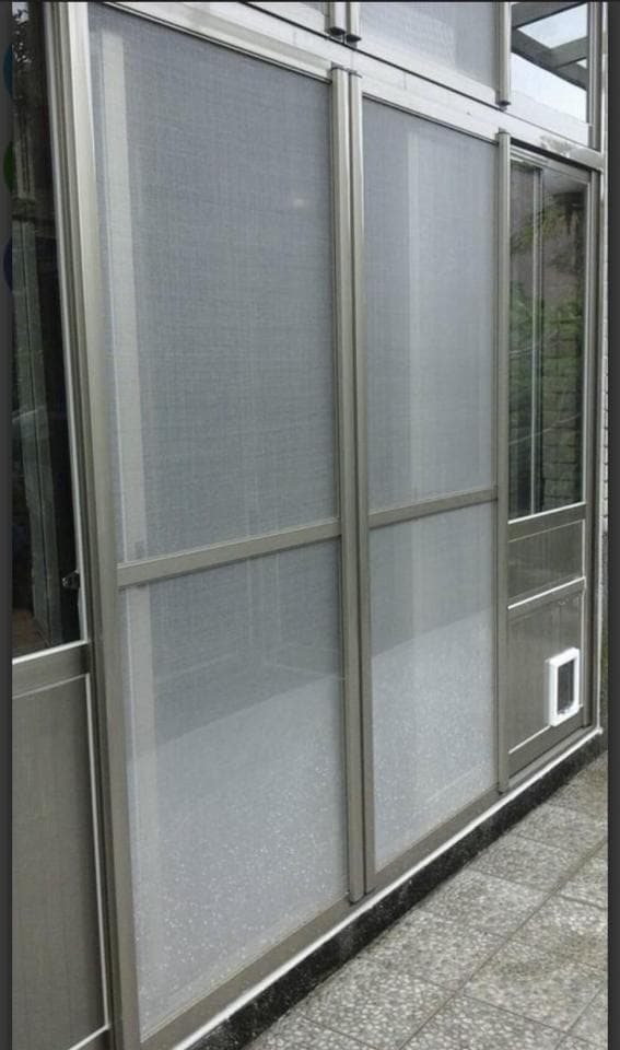 這張照片是一扇帶有寵物門的雙層紗窗門。