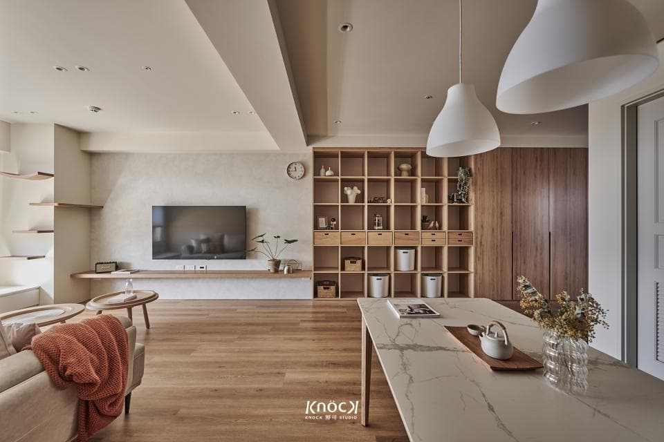 這張「現代風格客廳」的照片是一個寬敞明亮的空間,有著木質地板、淺色牆壁和簡約的傢俱。牆上掛著電視,旁邊有一個木質層架,上面擺放著裝飾品。房間裡還有一個大大的落地窗,讓陽光可以灑進室內,營造舒適的氛圍。