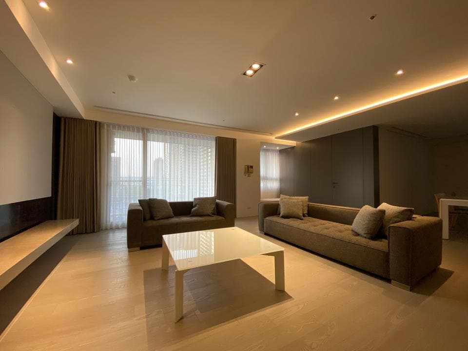 1) 這是一張現代客廳的室內照片,照片中包含沙發、茶几、窗簾、電視牆和裝飾,整體空間以簡潔、明亮的風格呈現