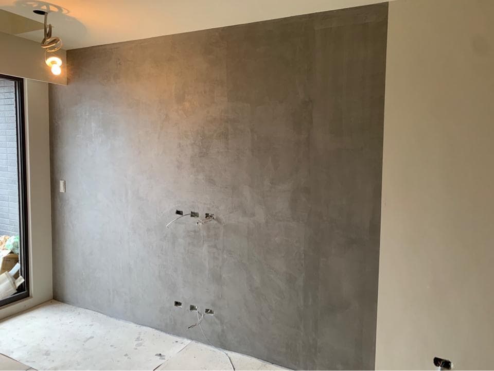 1) 照片顯示一個帶有水泥牆面的房間,左邊是窗戶,右邊是一面白牆