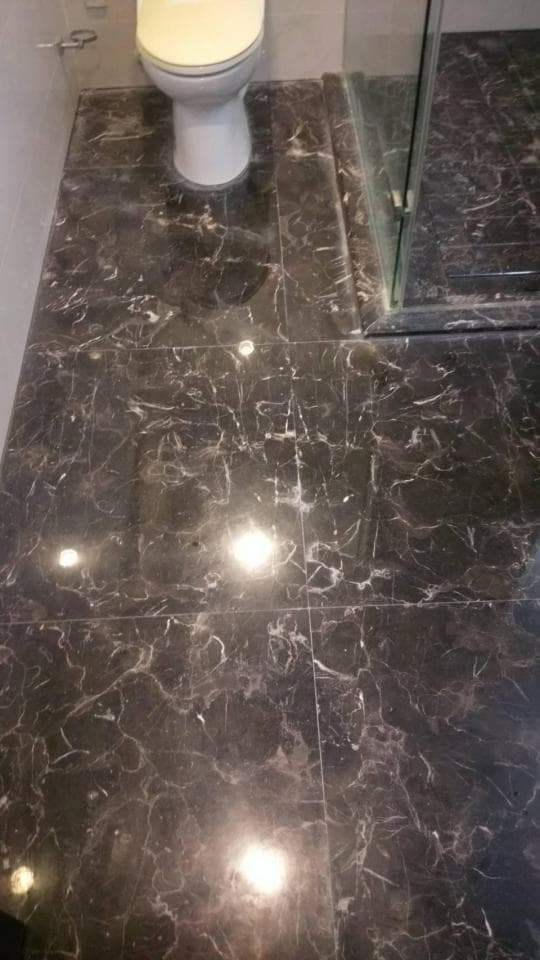 1) 照片顯示一個浴室的地板,地板由黑色和白色大理石瓷磚鋪成