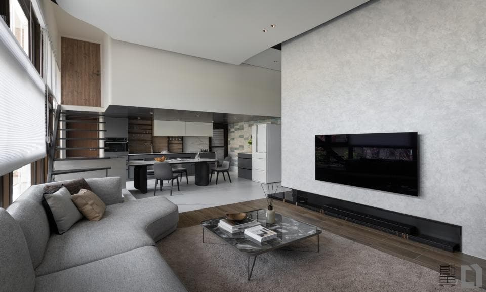 這張「客廳」的照片是一間明亮寬敞的空間,有灰色沙發、茶几和電視牆。