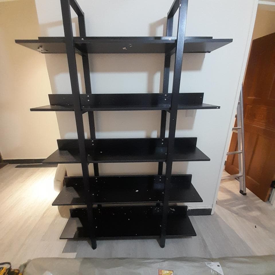 這張照片是一張黑色的四層書架,它看起來很堅固,而且很適合存放書本或其他物品。